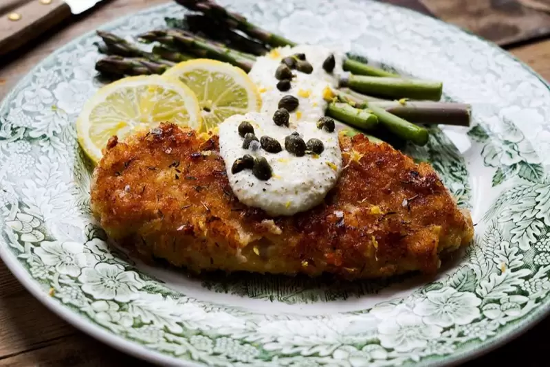 Kräuterschnitzel mit cremiger Zitronensauce und grünem Spargel